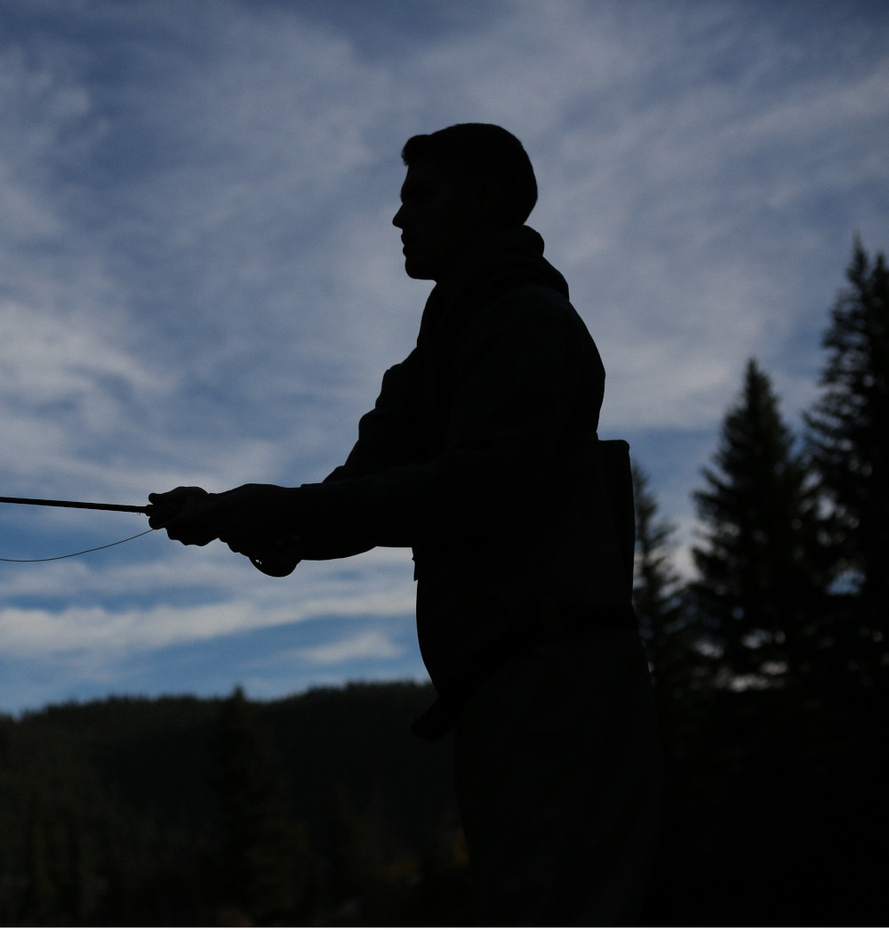 silhouette of fly fisherman