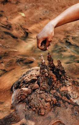 hand from above shaping an unappealing pile of mud