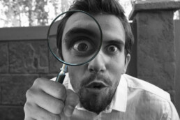 man looking through magnifying glass in astonishment