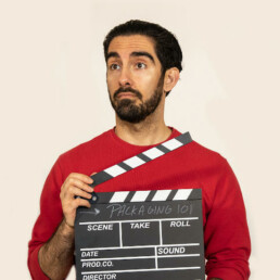Phillip Akhzar holding a director's clapperboard