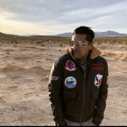 David Rastatter in a jacket standing in a desert scene